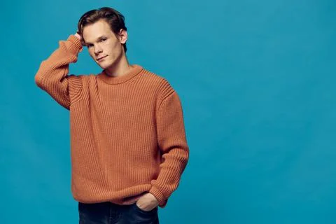 Man posing in a sweater on a blue background Stock Photos