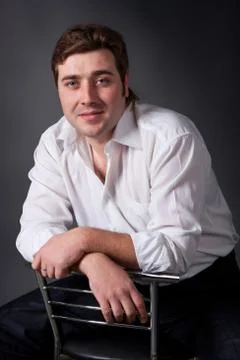 Man posing in white shirt on dark background Stock Photos