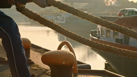 Man positioning Big Heavy Rope on Boat at Harbour Stock-Footage 120554078