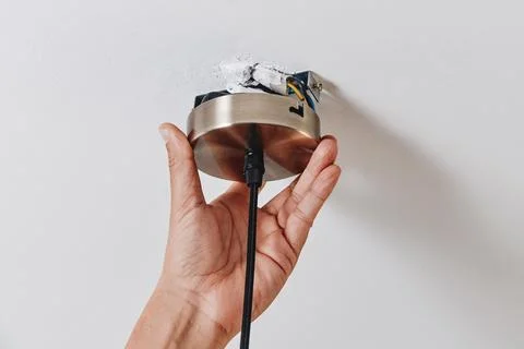 A man positions a ceiling light canopy on the ceiling Stock Photos