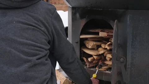 Man positions a gas burner so the flame keeps touching firewood Stock Footage 329227702