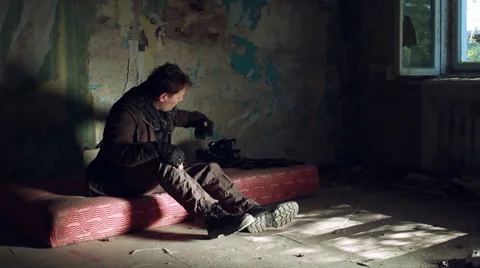 A man in a post apocalyptic clothes and a black gas mask comes in an abandoned Stock Footage 67978511