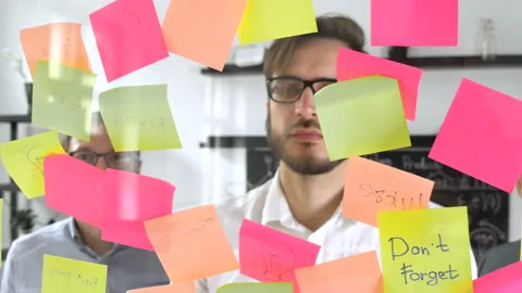 Man post in sticky note while meeting in office, on the sticker is written IDEA Stock Footage 86160155