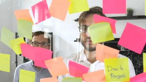 Man post in sticky note while meeting in office on the sticker is written N1 Stock Footage 86160917