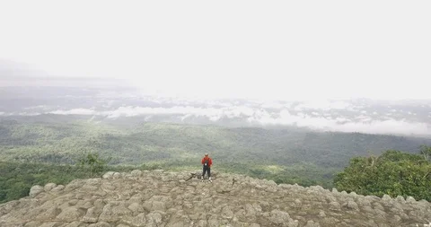 Man posting on mountain top aerial Stock Footage 89698246