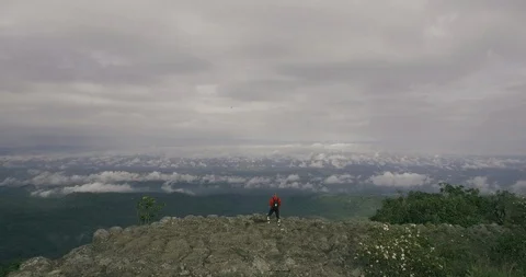 Man posting on mountain top aerial Stock Footage 89699265