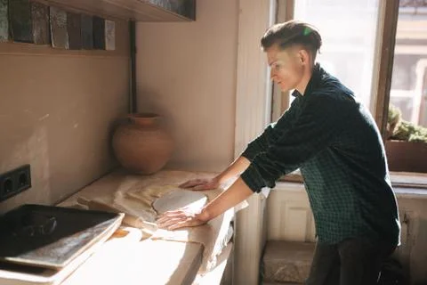 Man potter looking for ware for a work. Young man potter in his workshop Stock-Fotos