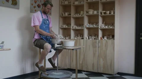 Man Potter is Rotating a Wheel Making a Pot Working on a Pottery Wheel Learning Stock Footage 57991515