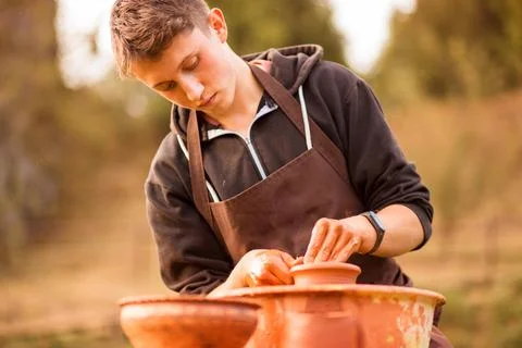 Man potter work with clay ware. Young man potter on his workshop with nature  Stock Photos