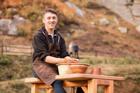 Man potter work with clay ware. Young man potter on his workshop with nature Stock Photos