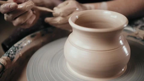 Man potter working on potters wheel making ceramic pot from clay in pottery Stock Footage 145030264