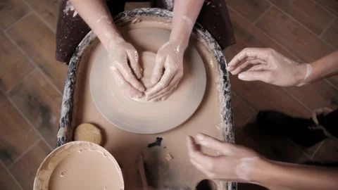 Man potter working on potters wheel making ceramic pot from clay in pottery Stock Footage 149999450