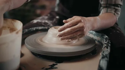 Man potter working on potters wheel making ceramic pot from clay in pottery Stock Footage 149999680