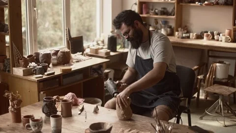 Man potter is working in pottery workshop, drying raw clay pot with Stock Footage 233725325