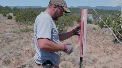 Man Pounding in Fence Post Stock Footage 94873682