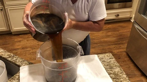 Man pouring a dark liquid Stock Footage 116551153