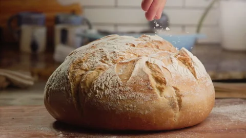 Man pouring flour on bread Stock Footage 153466388