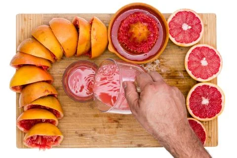 Man pouring freshly squeezed ruby grapefruit juice Stock Photos