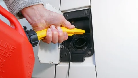 Man pouring fuel from a plastic container into a vehicle. Video stock 119768540