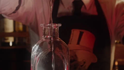 Man pouring liquid into a bottle Stock Footage 255702756