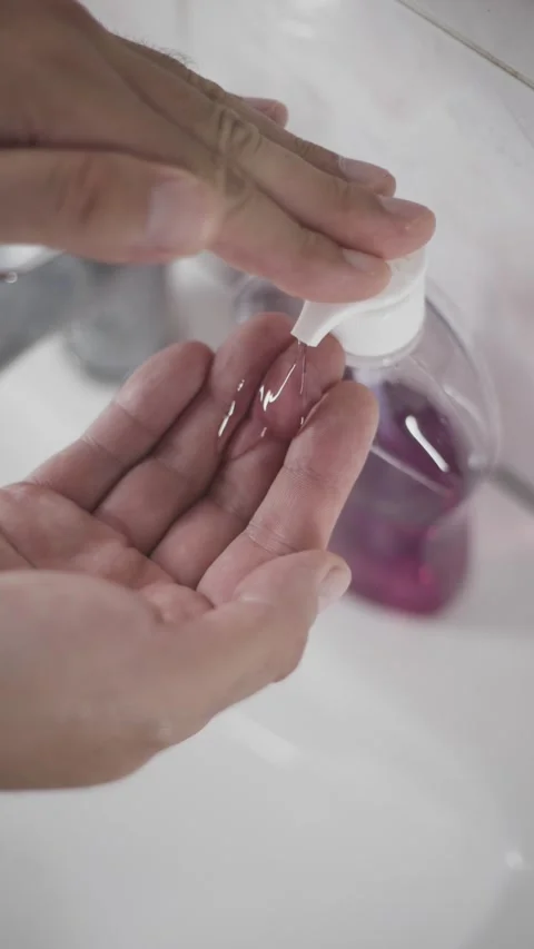 Man pouring liquid soap into hand closeup in bathroom vertical video reel Stock Footage 342240390