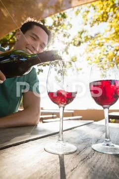 Man pouring red wine from bottle in glass Stock Photos