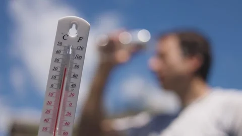 Man pouring water on his head in extreme heat. Thermometer in summer day shows o Stock Footage 280756942