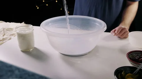 Man pouring water into large plastic bowl Video stock 132815582