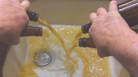 A man pours 4 bottles of spoiled waste cider or beer to the sink Видео 277543608