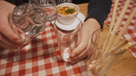 Man pours clean drinking water from a decanter into a glass. Close up. Stock Footage 99882459