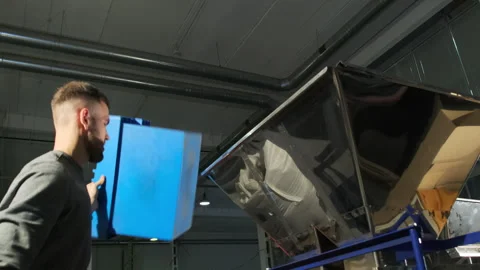 Man pours coffee beans from container into loading hopper Stock Footage 266914920