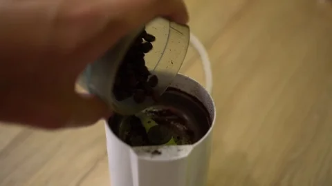 Man pours coffee beans in grinder. Close up shot Stock Footage 80129851