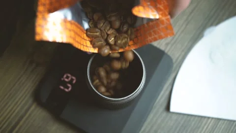 A man pours coffee beans into a manual coffee grinder Stock Footage 149597982