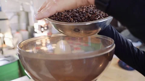 A man pours coffee beans into a transparent bowl of coffee grinder. Stock Footage 122149796