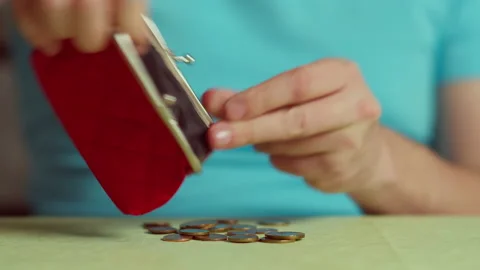 A man pours coins on the table from a red wallet and counts, close-up Video stock 145005463