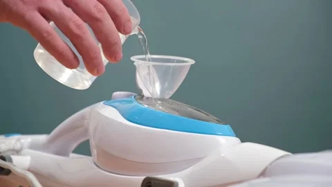 A man pours distilled water into steam c... | Stock Video | Pond5