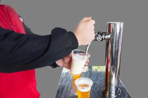Man pours draft beer in plastic glass during picnic. Close up isolated image  스톡 사진