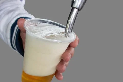 Man pours draft beer in plastic glass during picnic. Close up isolated image  Stock-Fotos