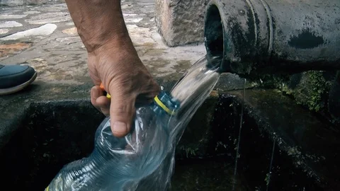 A man pours drinking water in a plastic bottle Stock-Footage 125255777