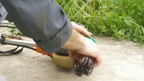 The man pours gasoline into the braid. Prepares it to work not his own plot. Stock Footage 76466733