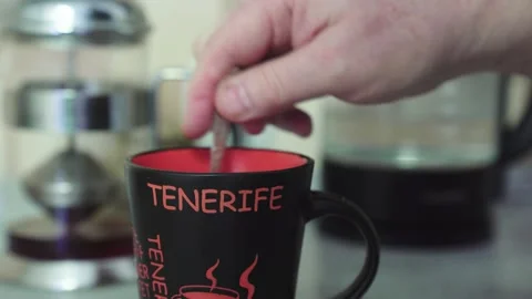 Man pours hot tea from clear teapot at home on kitchen table Stock Footage 223210313