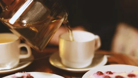 A man pours hot tea into cups Stock Footage 104144358
