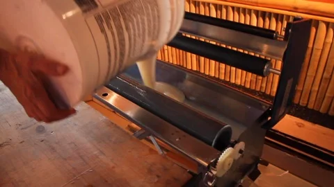Man pours liquid glue paste out of large bucket Stock Footage 125057223