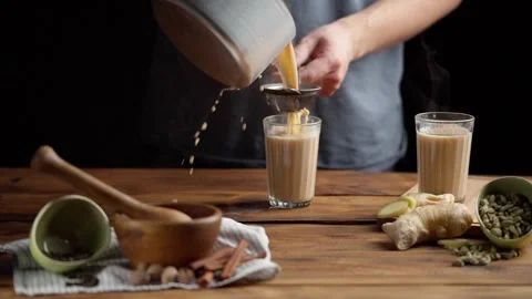 A man pours masala tea into a cut glass. Stock Footage 255291316