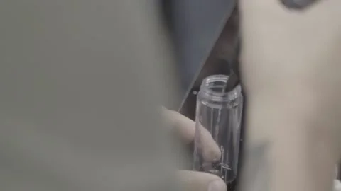 A man pours an oxidizing agent for paint into a measuring tube at a barbershop. Stock Footage 144639369