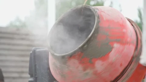A man pours a plasticizer from a bucket into a working crown mixer, close-up Stock Footage 238968804