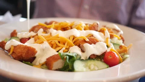 Man Pours Ranch Dressing over Cheesy Fried Chicken Salad Vidéo 325635427