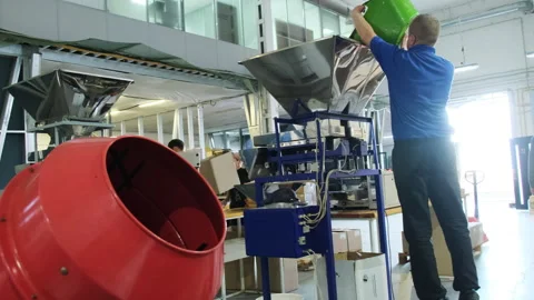 Man pours raw coffee beans from container into loading hopper Stock Footage 266142562