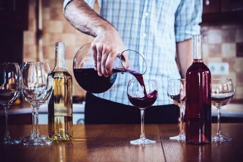 Man pours red wine Foto stock