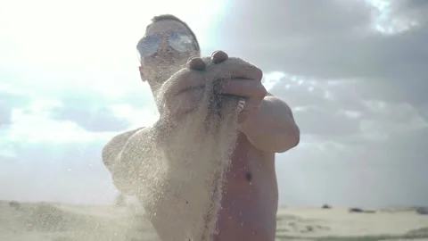 Man pours sand through his fingers Stock Footage 89690686